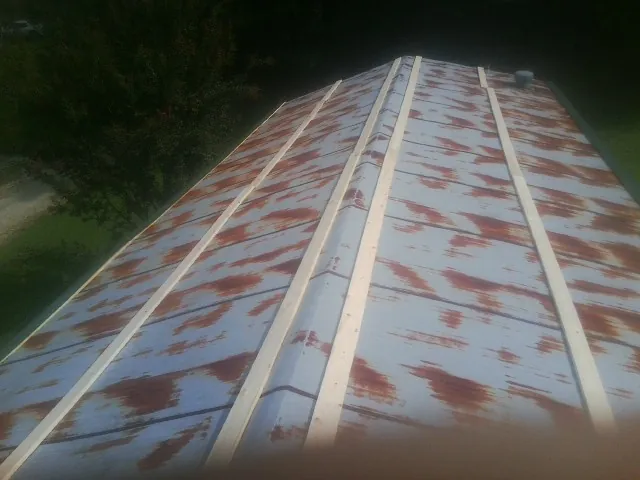 Rusted metal roof panels with new wood purlins before replacement — Storm Damage Roof Repair in Altoona by Roofing Brothers
